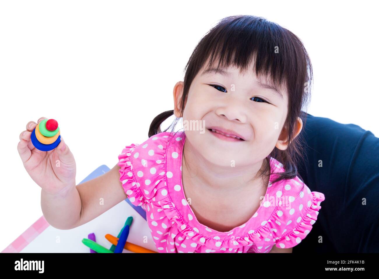 Petite fille asiatique jouant et créant des jouets à partir de la pâte de jeu. Enfant souriant et de montrer ses œuvres de l'argile, sur fond blanc. Renforcer l'imagination Banque D'Images