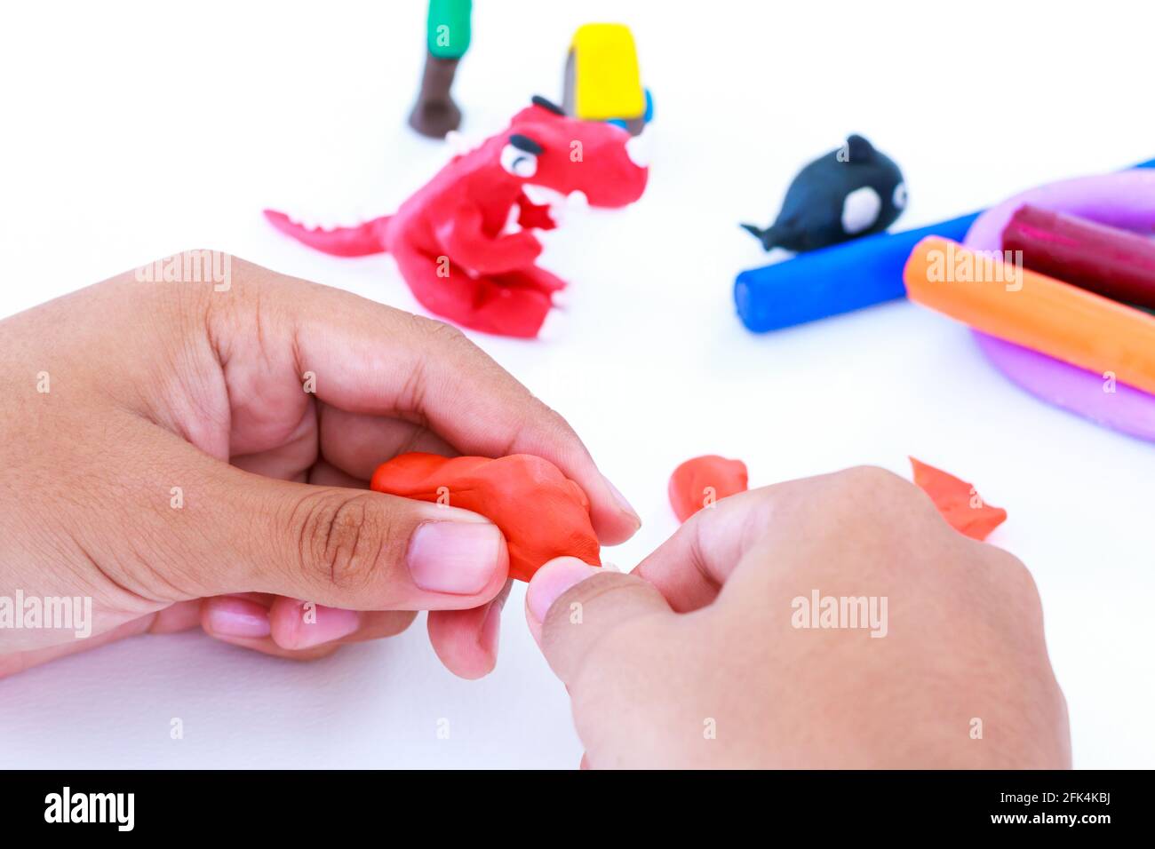 Enfant jouant et créant des jouets à partir de la pâte de jeu. Argile à modeler de moulage enfant. Renforcer l'imagination de l'enfant. Banque D'Images