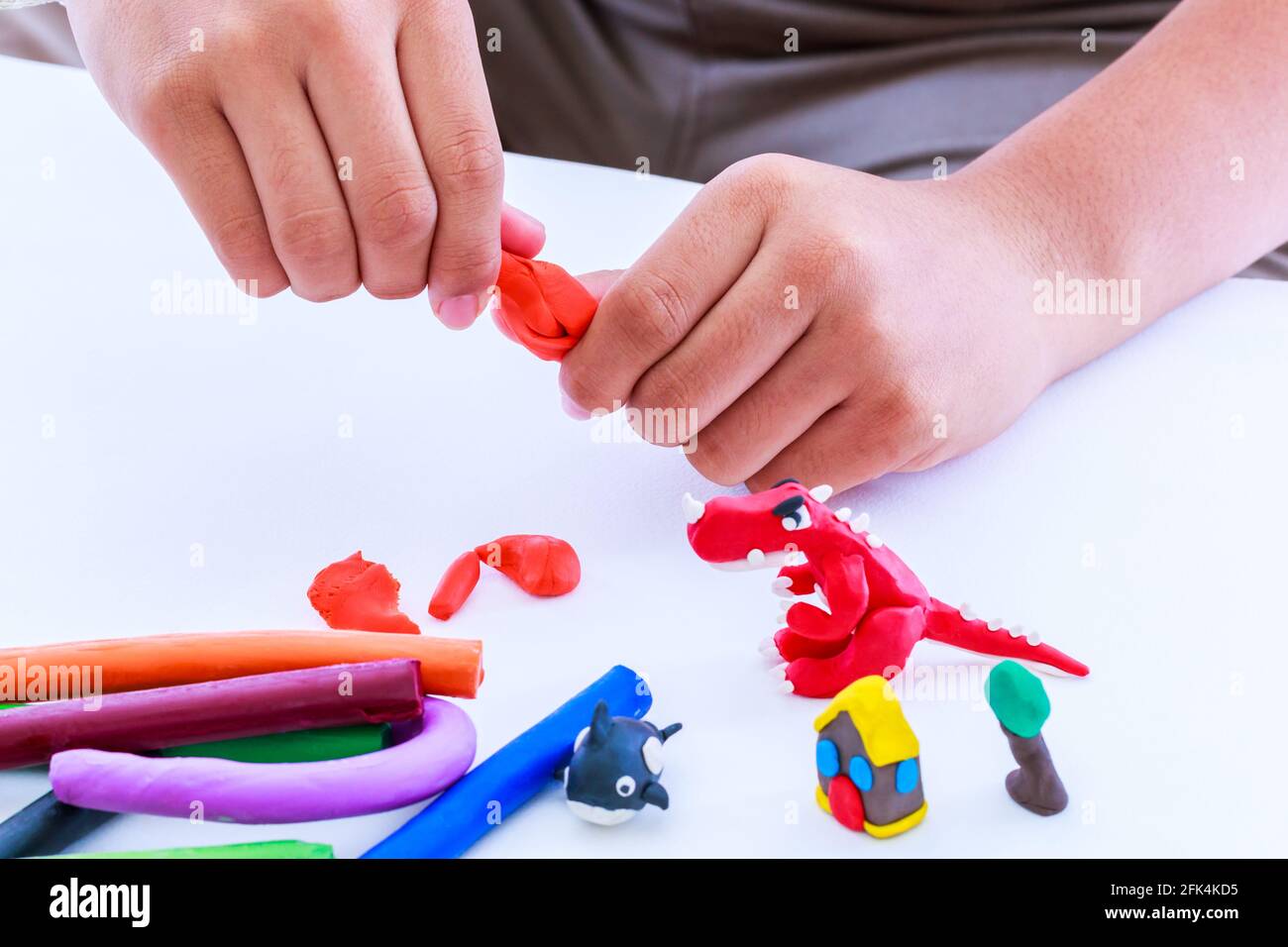 Enfant jouant et créant des jouets à partir de la pâte de jeu. Argile à modeler de moulage enfant. Renforcer l'imagination de l'enfant. Banque D'Images