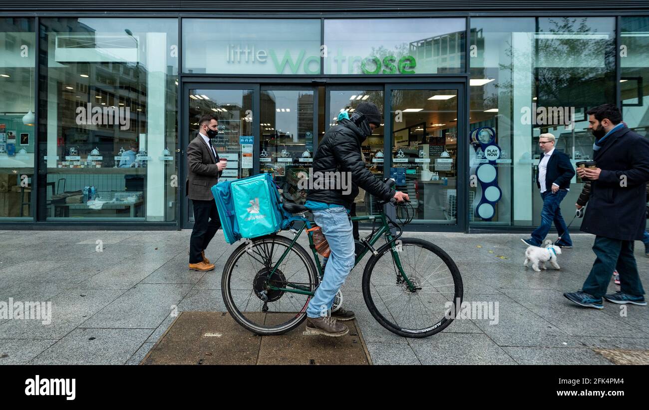 Londres, Royaume-Uni. 28 avril 2021. Un pilote Deliveroo collecte une commande en dehors d'une succursale de Waitrose dans Bankside. Waitrose et Deliveroo ont annoncé un partenariat de deux ans pour des livraisons de maisons rapides qui créera 400 nouveaux emplois à Waitrose pour remplir les commandes devant être collectées par Deliveroo. Le nouvel accord vient après que Waitrose et le épicier en ligne Ocado ont fini de travailler ensemble l'année dernière. Credit: Stephen Chung / Alamy Live News Banque D'Images