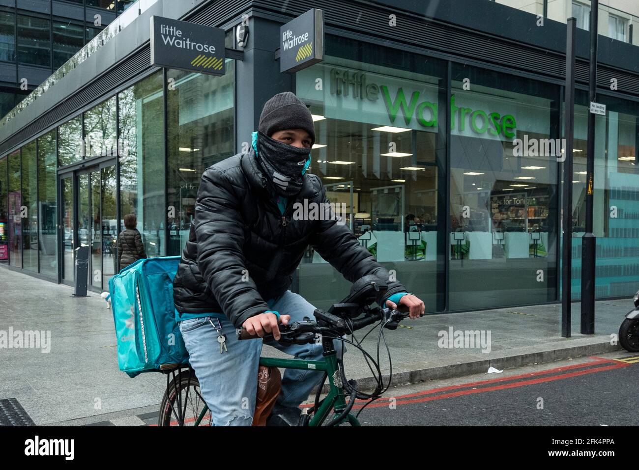 Londres, Royaume-Uni. 28 avril 2021. Un pilote Deliveroo collecte une commande en dehors d'une succursale de Waitrose dans Bankside. Waitrose et Deliveroo ont annoncé un partenariat de deux ans pour des livraisons de maisons rapides qui créera 400 nouveaux emplois à Waitrose pour remplir les commandes devant être collectées par Deliveroo. Le nouvel accord vient après que Waitrose et le épicier en ligne Ocado ont fini de travailler ensemble l'année dernière. Credit: Stephen Chung / Alamy Live News Banque D'Images