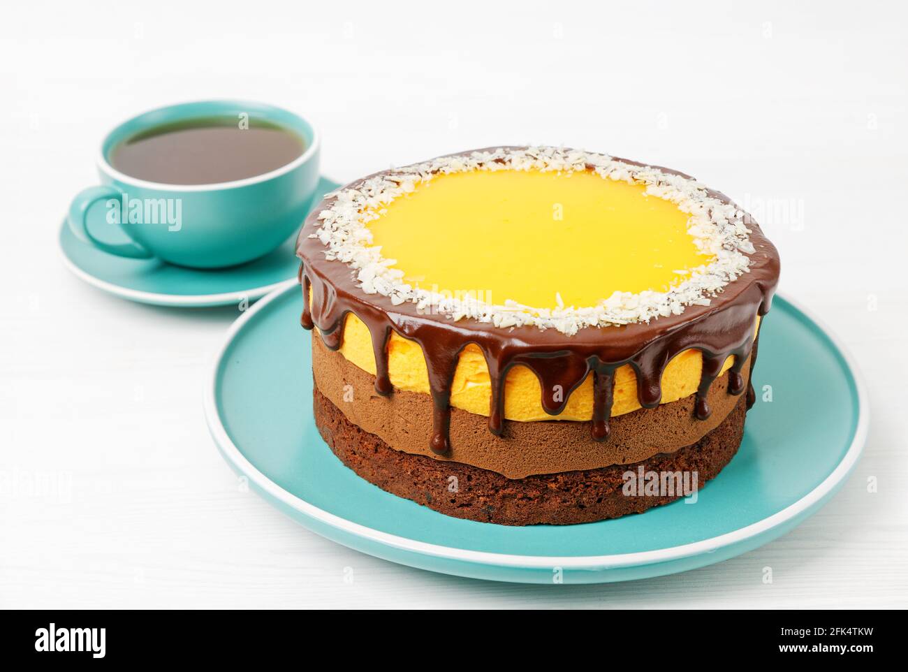 Gâteau au chocolat et à l'orange maison parsemé de tranches d'amande et d'une tasse de thé sur une table en bois blanc. Banque D'Images Gâteau au chocolat et à l'orange maison parsemé de tranches d'amande et d'une tasse de thé sur une table en bois blanc. Banque D'Images