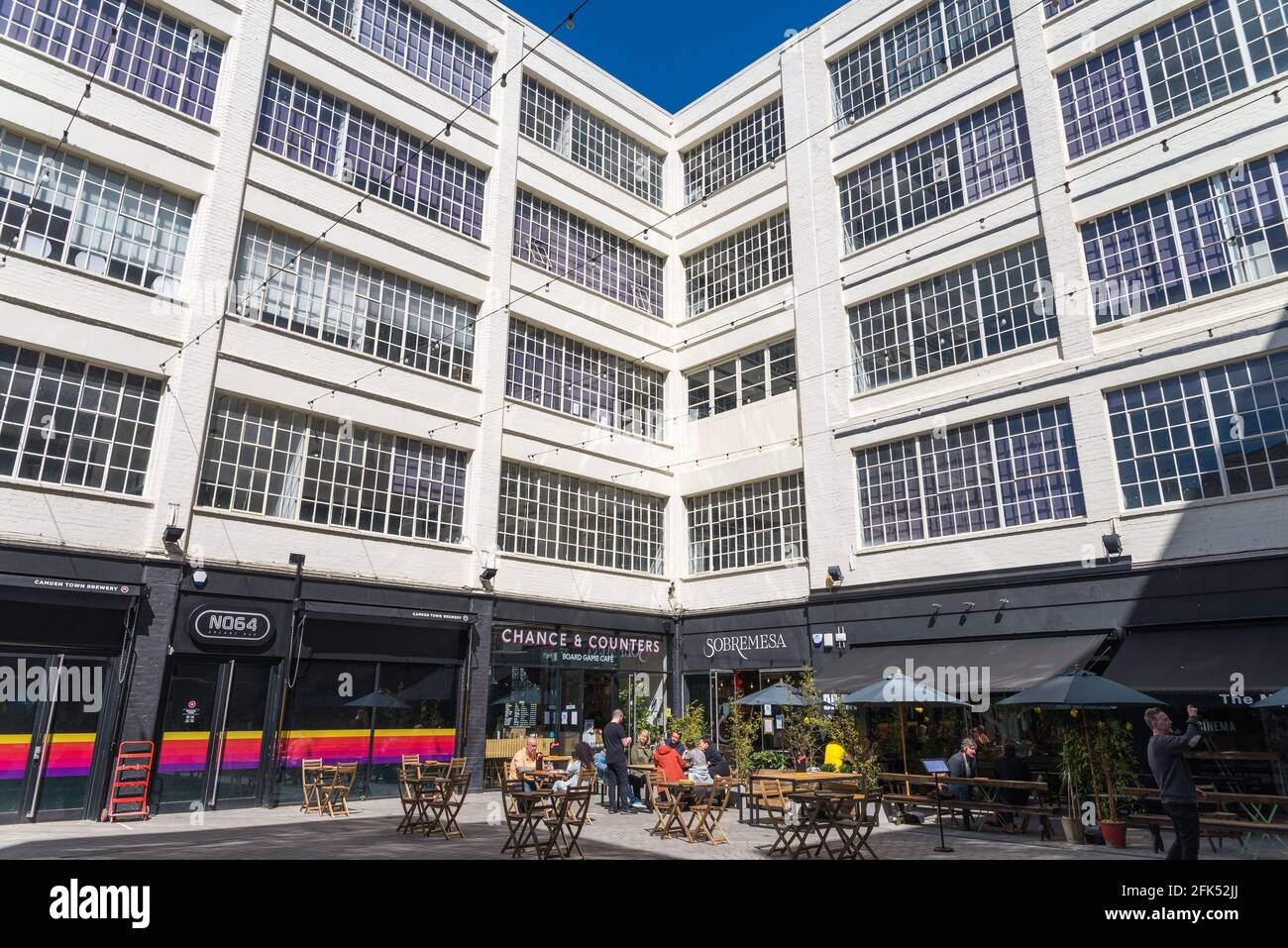 Les gens assis dehors manger et boire dans la cour dans le quartier créatif à la Custard Factory à Digbeth, Birmingham, Royaume-Uni Banque D'Images