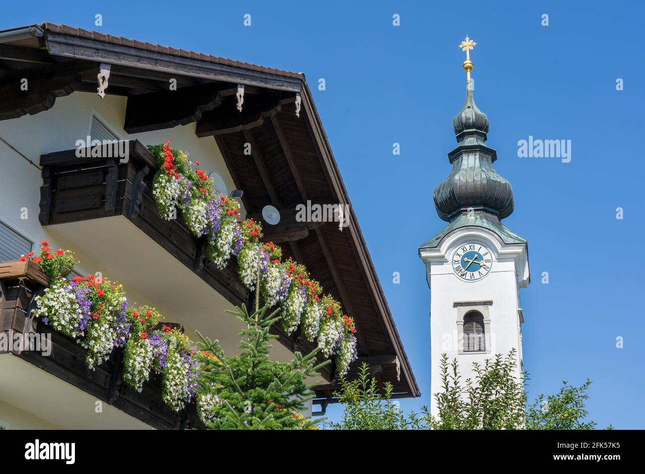 Die Kirche von Ulrichshögl mit einem blumengeschmückten Bauernhaus im Vordergrund Banque D'Images