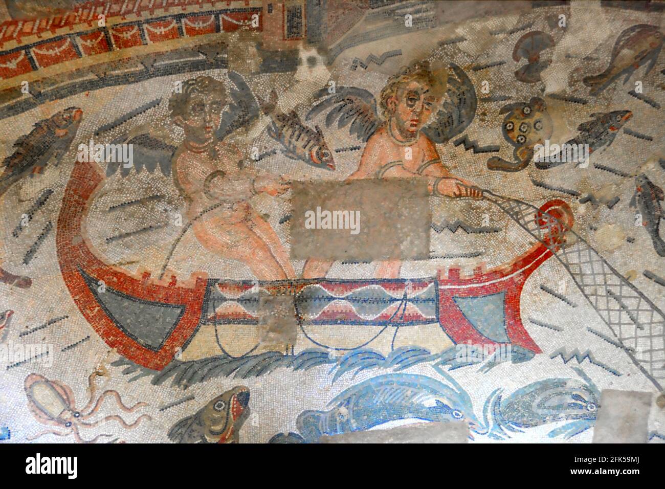 Mosaïque romaine antique de cupids pêche dans un bateau dans une mer pleine de poissons. Une allégorie pour trouver l'amour. Des mosaïques romaines anciennes classées au patrimoine mondial de l'UNESCO Banque D'Images