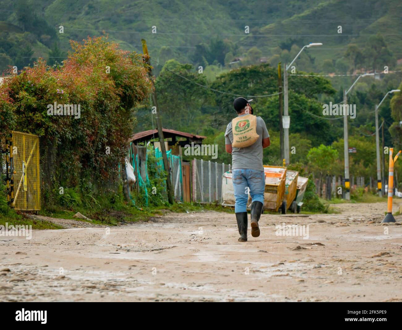 Guatapé, Antioquia, Colombie - avril 4 2021 : Latino-homme portant un sac de jute dans son dos Banque D'Images