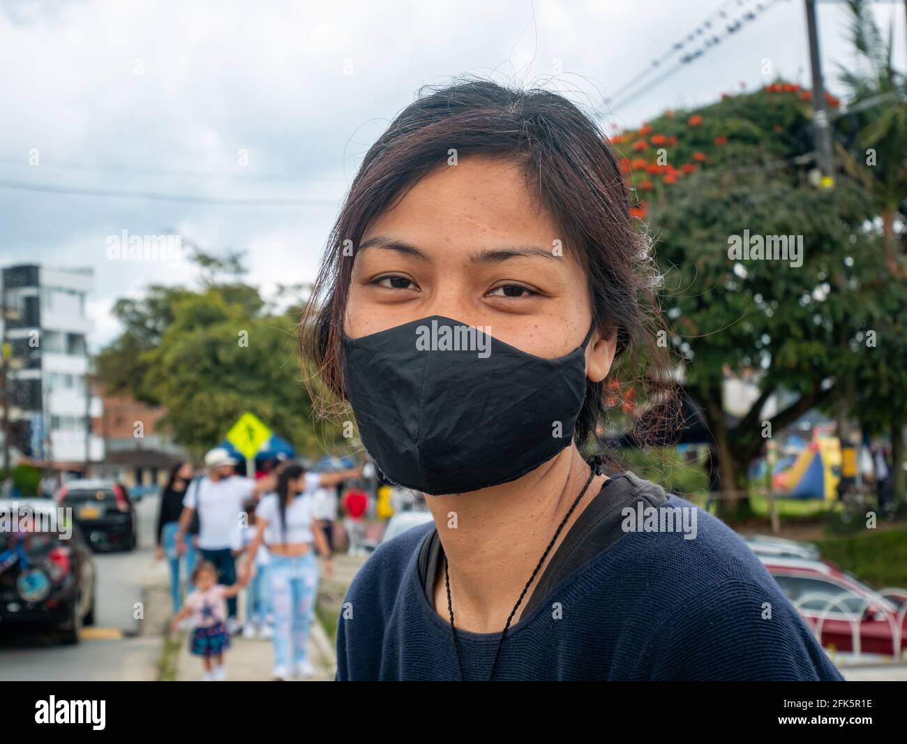 Guatape, Antioquia, Colombie - avril 4 2021: Jeune femme asiatique regardant la caméra au milieu des autres touristes Banque D'Images
