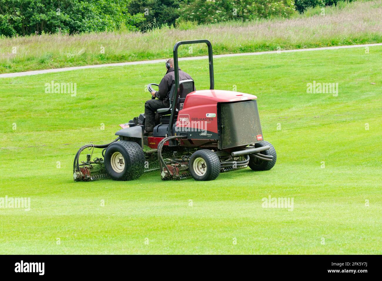 Un green-keeper de terrain de golf sur une tondeuse à gazon. Banque D'Images