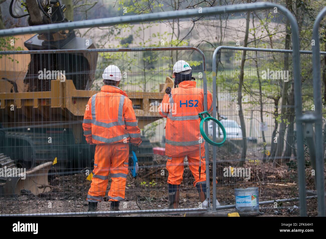 Wendover, Royaume-Uni. 28 avril 2021. Les travailleurs du HS2 observent qu'un gros creuseur mécanique est utilisé pour la « translocation » du sol comme mesure d'atténuation environnementale pour la liaison ferroviaire à grande vitesse du HS2 dans la forêt ancienne de Jones Hill Wood, dans l'AONB de Chilterns. L'abattage des bois qui contiennent des lieux de repos et/ou des sites de reproduction de la Pipistrelle, de la barbastelle, de la noctule, de la marron à longues oreilles et de la chauve-souris nattererÕs a repris ses fonctions après qu'un juge de la haute Cour ait refusé hier l'autorisation du militant Mark Keir de demander un contrôle judiciaire et a levé une injonction sur les bombardements. Crédit : Mark Kerrison/Alamy Live New Banque D'Images