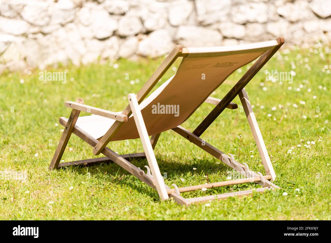 Chaise longue sur l'herbe sous le soleil. Un endroit pour bronzer. Chaise  en bois avec tissu Photo Stock - Alamy