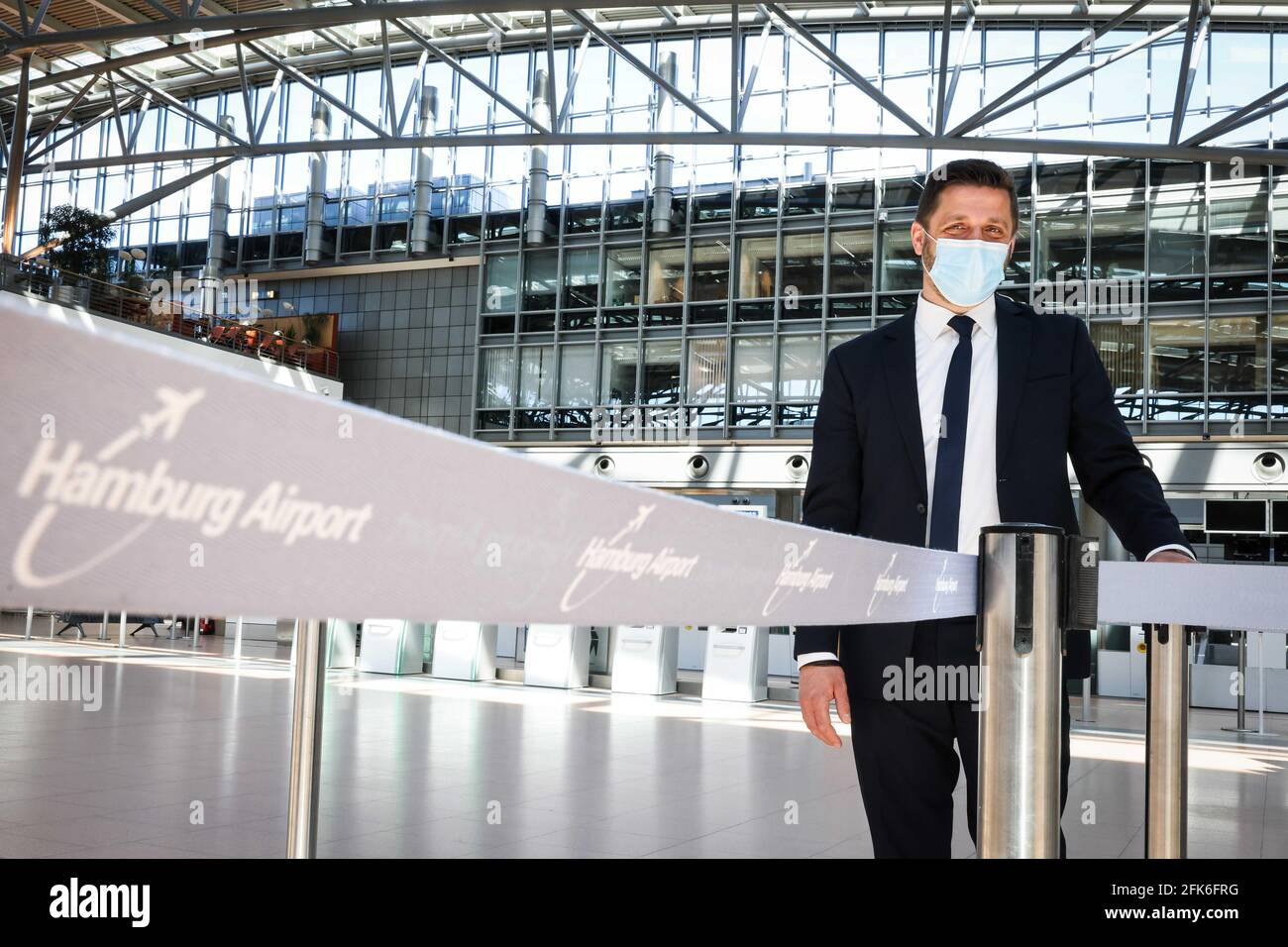 Hambourg, Allemagne. 27 avril 2021. Stefan Dechow, un ingénieur aéronautique, se trouve dans le terminal fermé 2 de l'aéroport de Hambourg, portant un nez et une porte-bouche. Seulement environ dix pour cent des passagers habituels sont actuellement à bord d'un avion dans la ville hanséatique. L'aéroport a été certifié par l'association aéroportuaire mondiale Airports Council International en ce qui concerne la norme de ses mesures de protection et d'hygiène corona. (À dpa 'aéroport de Hambourg: Terminal vide, certificat Corona et routine') crédit: Christian Charisius/dpa/Alay Live News Banque D'Images