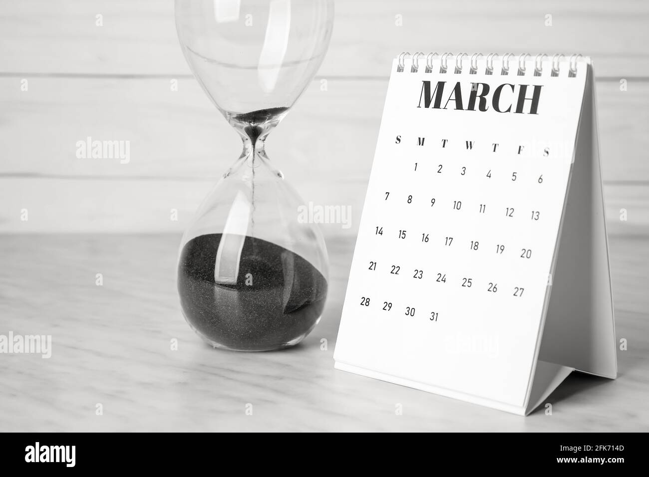 Retourner le calendrier papier avec le sablier sur la table Photo Stock -  Alamy