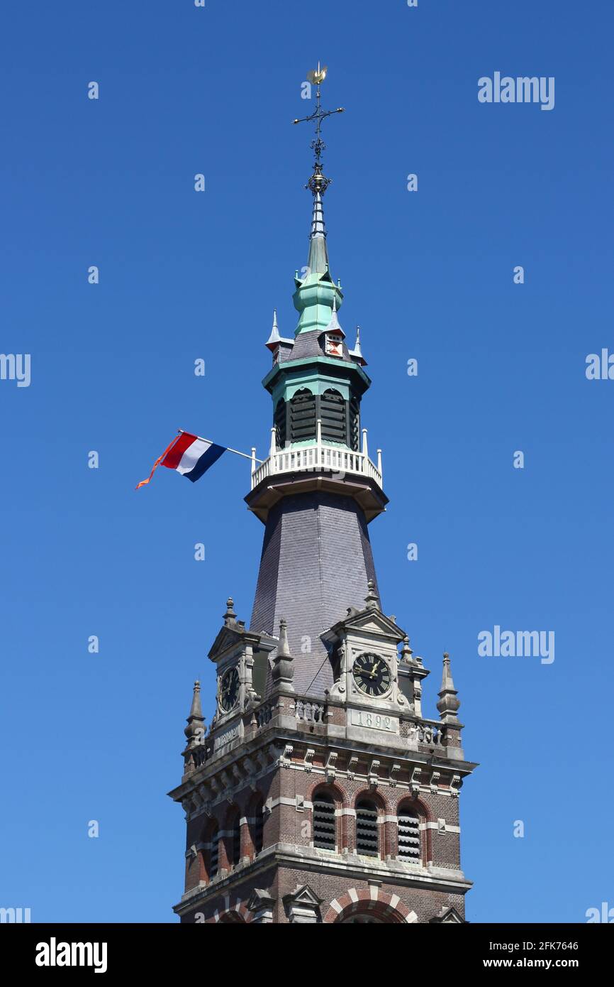 La tour de la Grande église dans la ville hollandaise d'Apeldoorn le jour national hollandais 'Koningsdag' (le jour du Roi), avec le drapeau national et le ruisseau orange. Banque D'Images