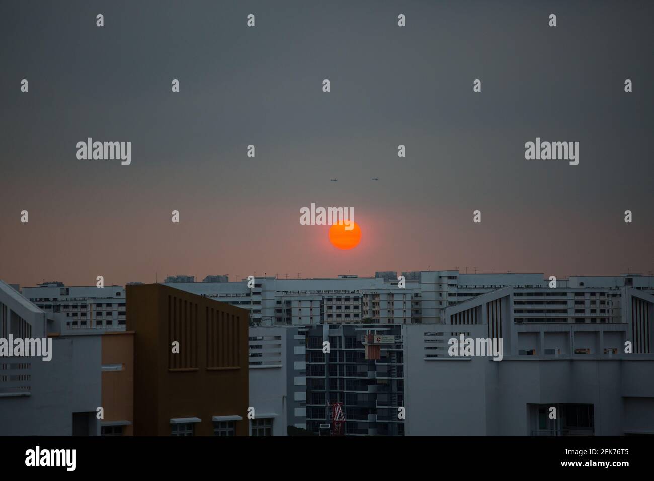 Vue flamboyante sur le coucher du soleil et deux hélicoptères qui volent dans le ciel. Singapour. Banque D'Images