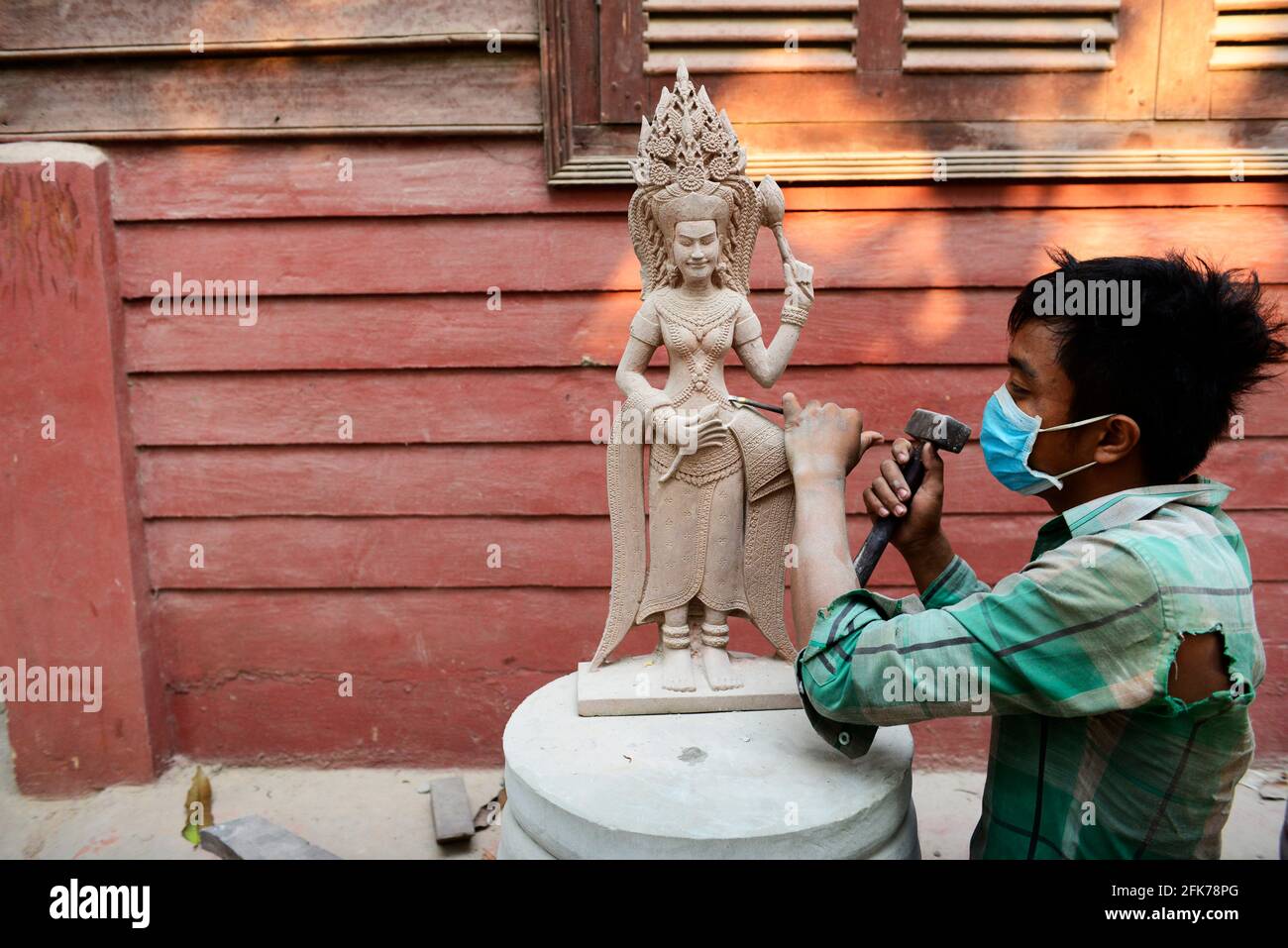 Un sculpturiste khmer travaillant sur sa sculpture d'Apsara à Siem Reap, Cambodge. Banque D'Images