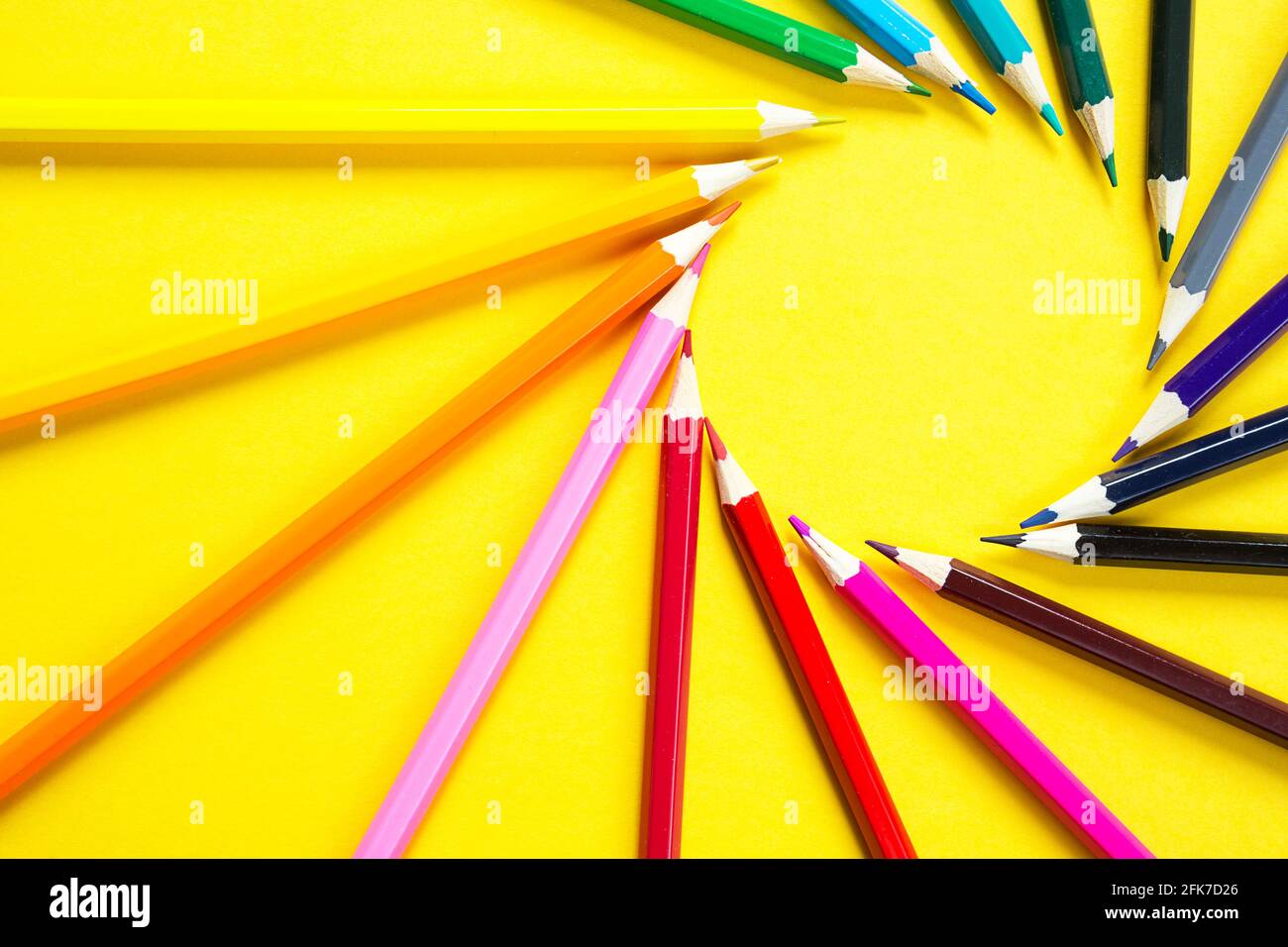 Jeu de crayons colorés sur fond jaune est disposé dans un cercle en forme de soleil. CopySpace, cadre. Retour à l'école, artiste, dessin moins Banque D'Images