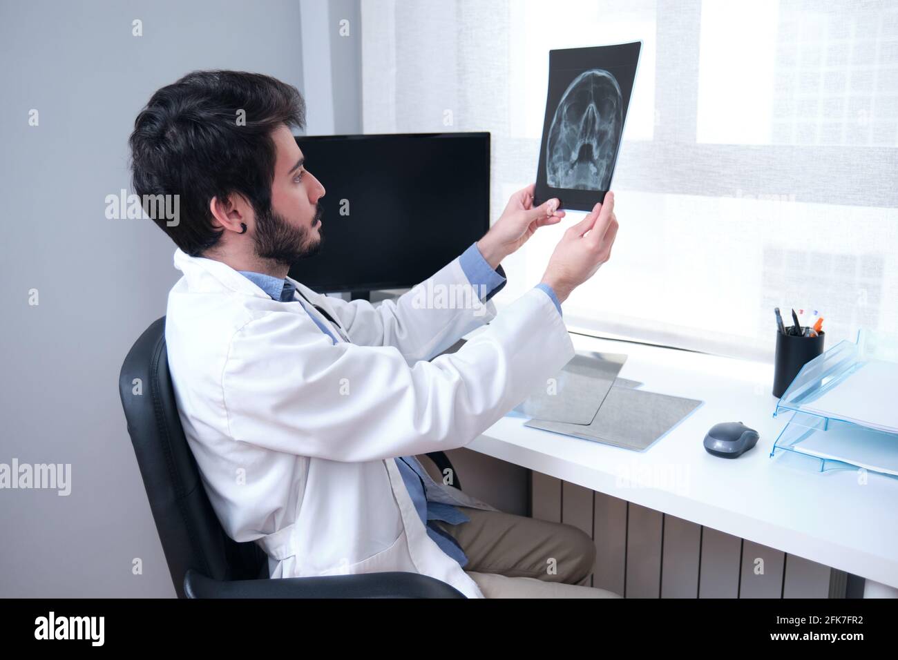 Jeune médecin examinant la radiographie du crâne, des sinus. Radiographie d'une tête. Banque D'Images
