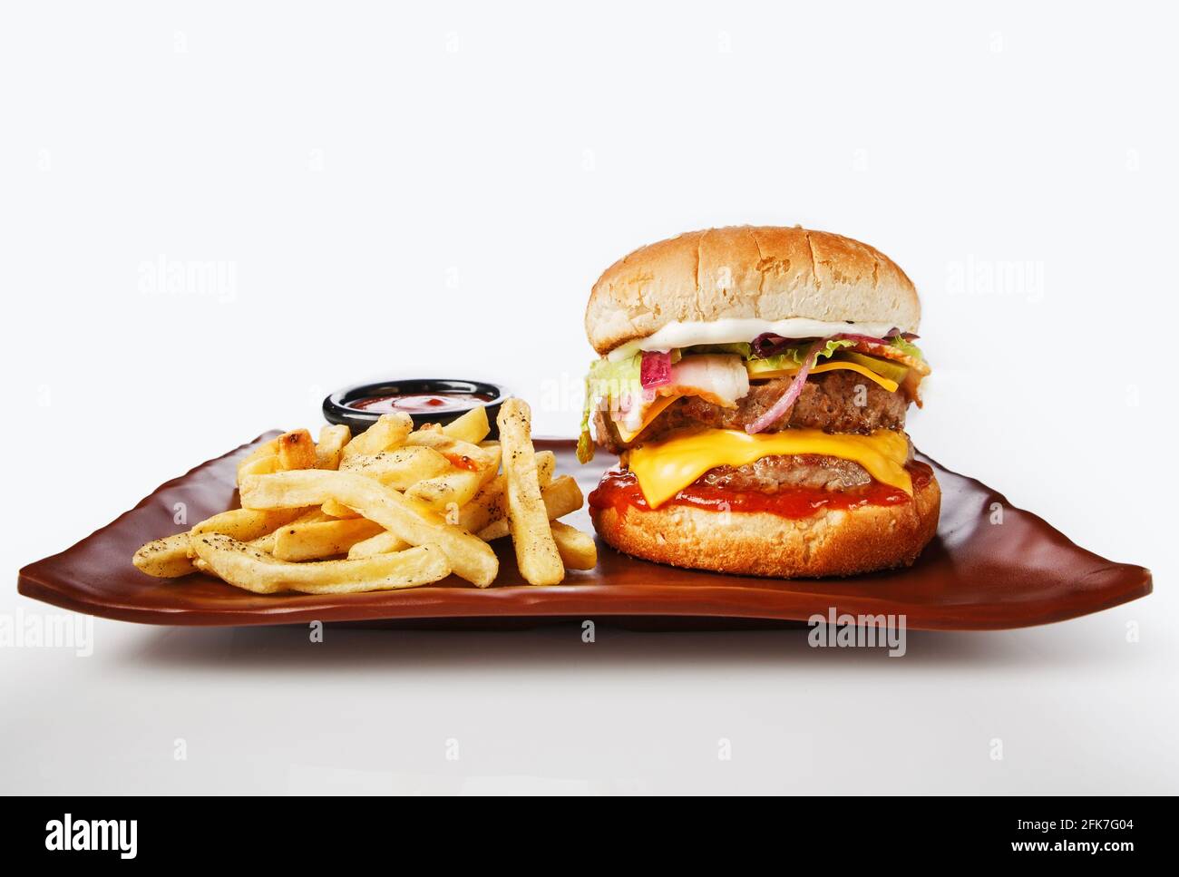 Hamburger. Côtelette de porc juteuse, cheddar, oignons croquants, laitue enveloppée dans un pain sous deux sauces. Servi avec des frites et de la sauce à la crème. Banque D'Images