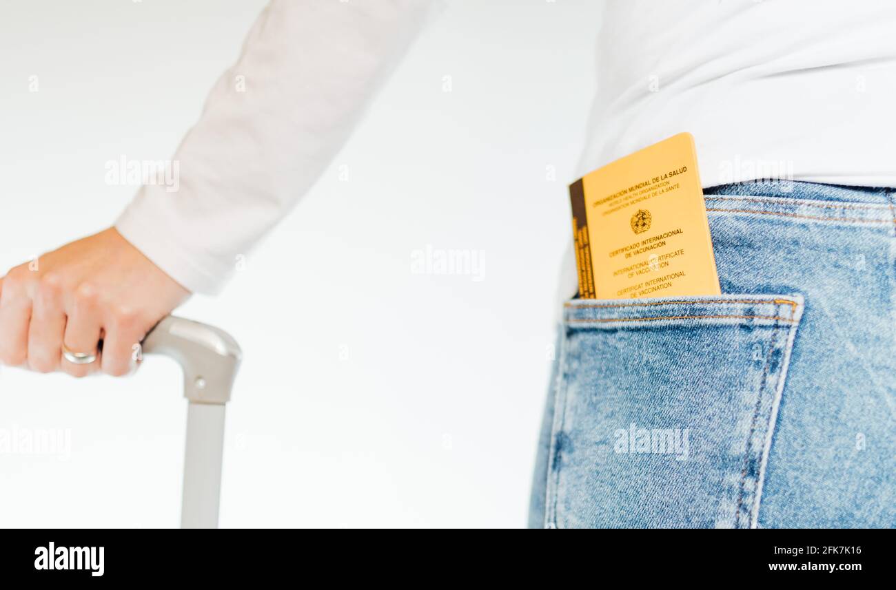 Une jeune femme avec sa valise se prépare à voyager après la pandémie mondiale du coronavirus, covid-19 avec son certificat de vaccination, covid-19 imm Banque D'Images