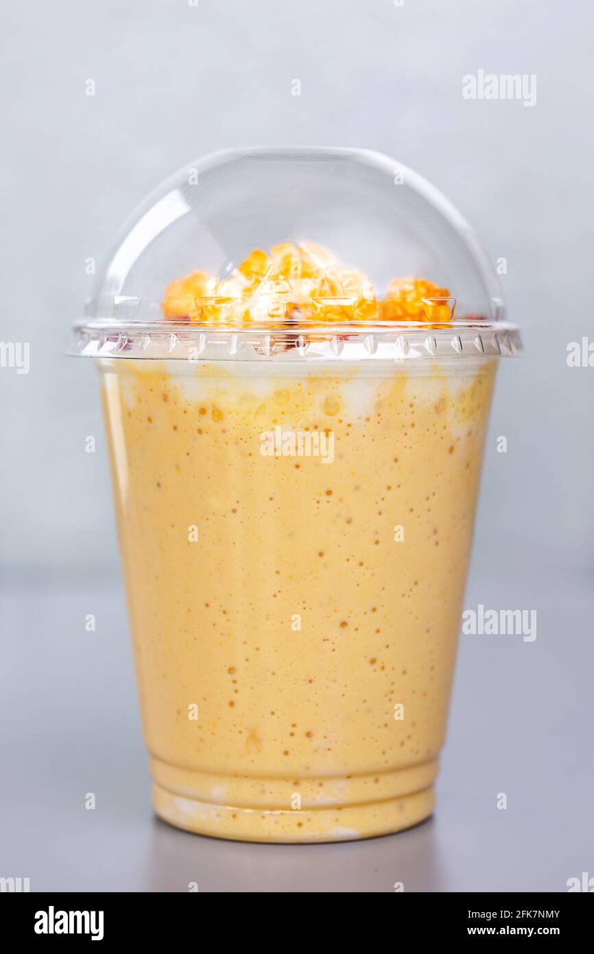 cocktail au lait sucré avec pop-corn dans un verre en plastique. Banque D'Images