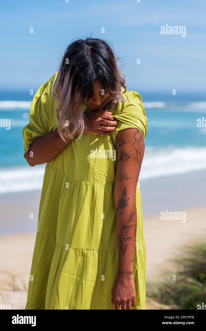 Femme regardant les tatouages sur ses bras Banque D'Images