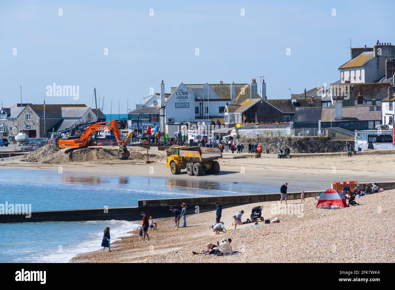 Lyme Regis, Dorset, Royaume-Uni. 29 avril 2021. Météo Royaume-Uni. Une belle journée ensoleillée et lumineuse avec une brise fraîche à la station balnéaire de Lyme Regis. Les gens étaient à l'extérieur et sur le point de profiter de la belle belette malgré le refroidissement dans l'air et les travaux de dragage de plage entrepris par Dorset Council en préparation pour la saison des fêtes. Credit: Celia McMahon/Alamy Live News Banque D'Images