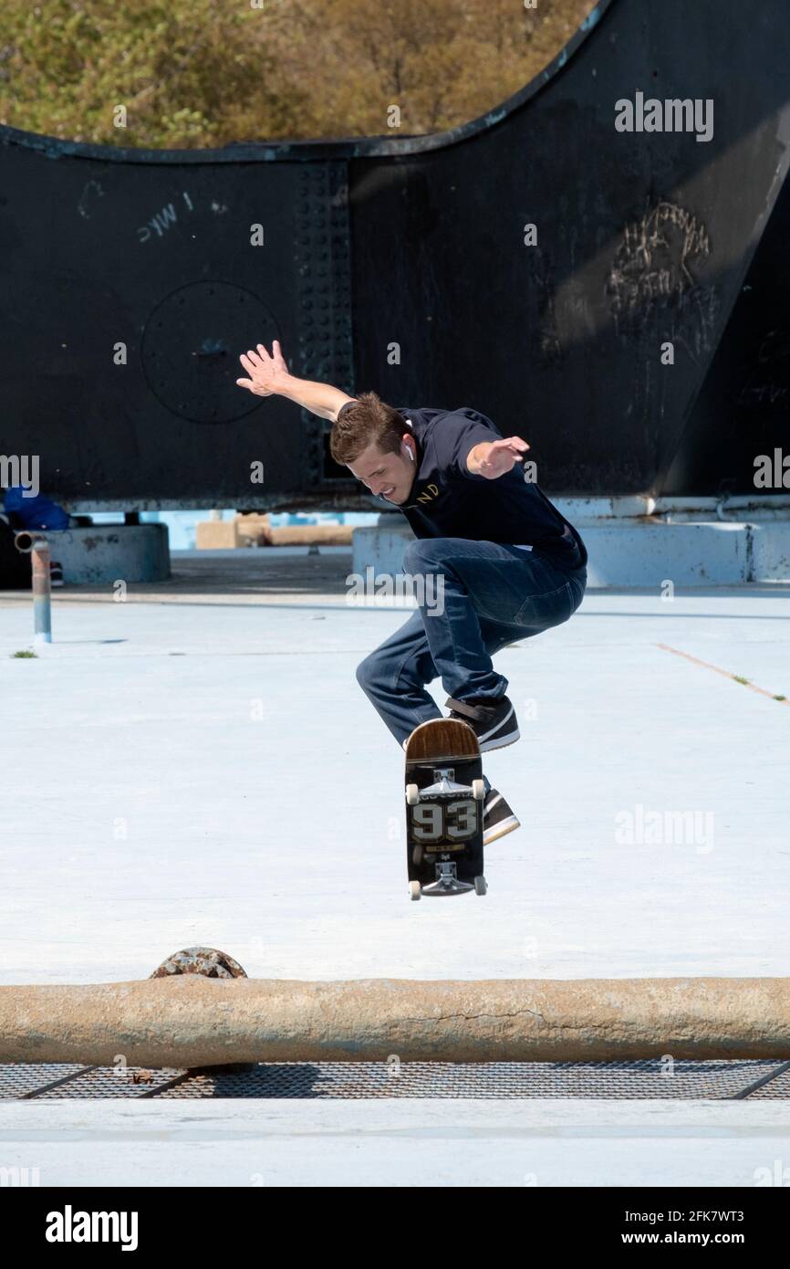 Avec la base Unisphere en arrière-plan, un skateboarder surmonte un obstacle. À Flushing Meadows Corona Park, Queens, New York Banque D'Images