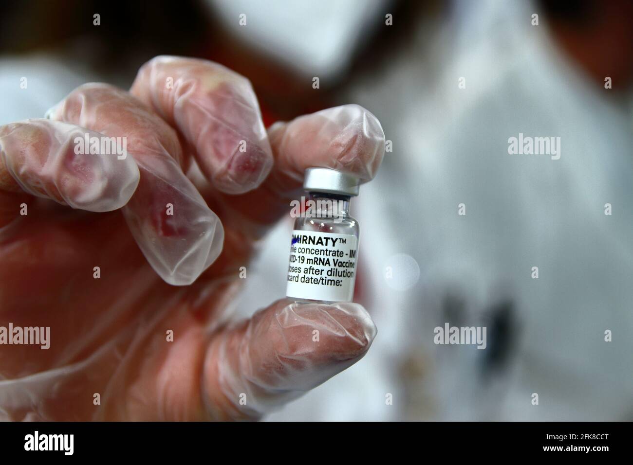 Infirmière à l'intérieur de la pharmacie tout en préparant une seringue pour l'administration du vaccin astrazeneca.Détail du flacon contenant le vaccin. Banque D'Images