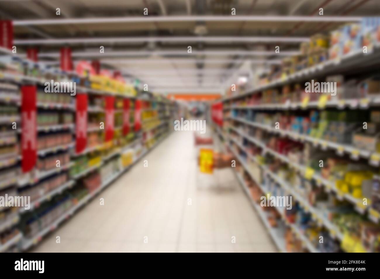 Une allée de supermarché floue et abstraite avec des étagères colorées. Banque D'Images