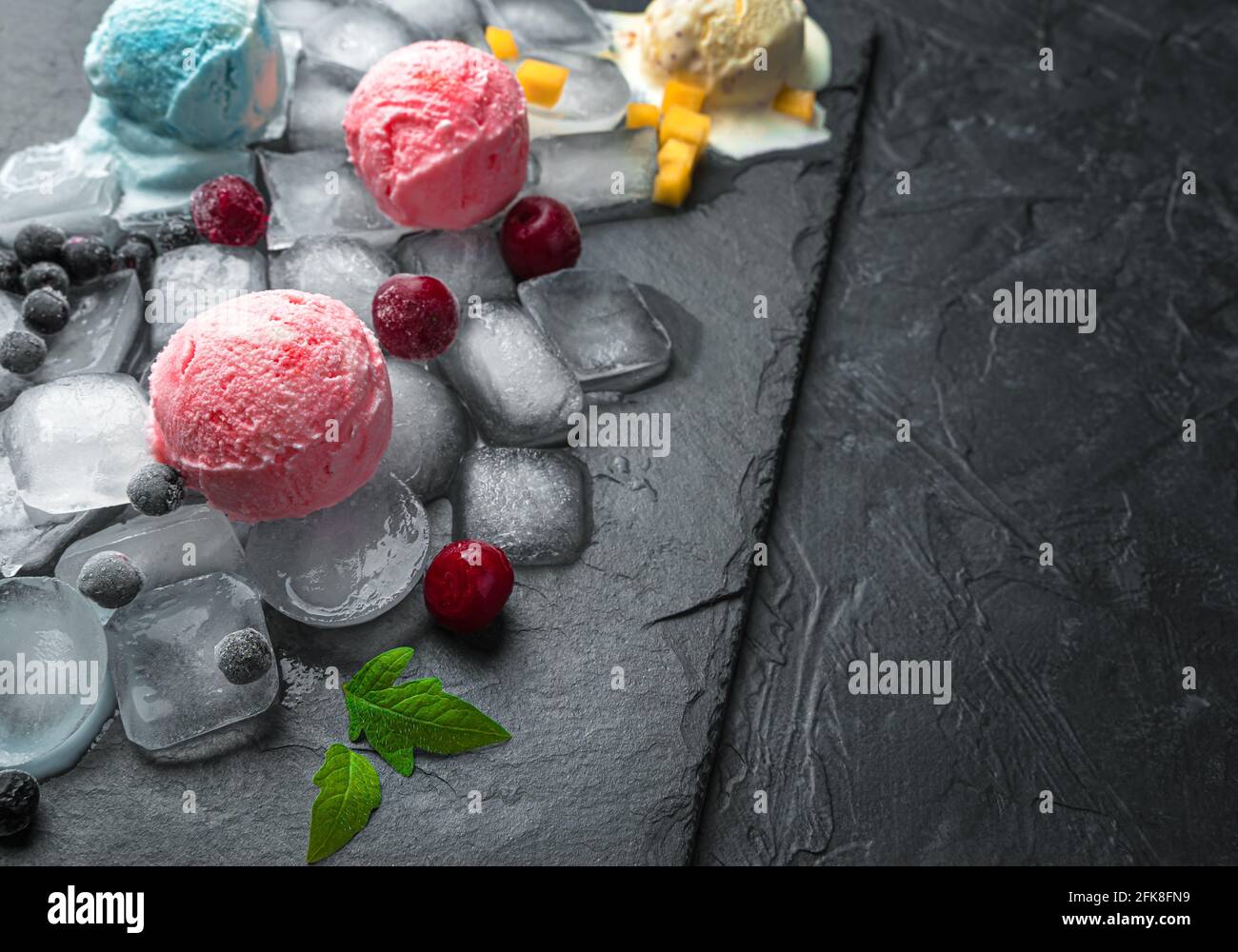 Glace aux baies et aux fruits sur glace sur fond noir avec espace à copier. Banque D'Images