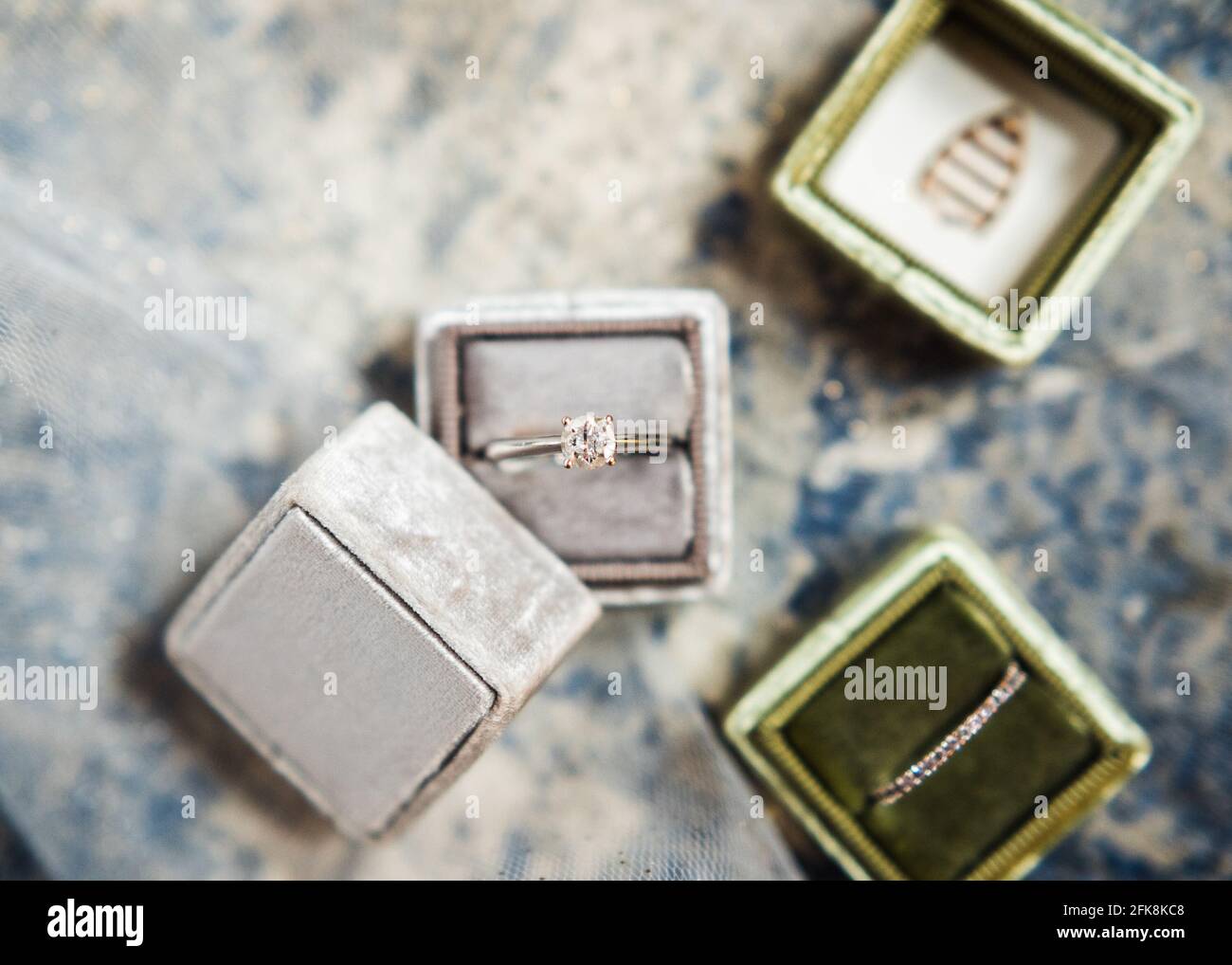 Boîtes à anneaux de mariage en gris et vert, dans un plat. Banque D'Images