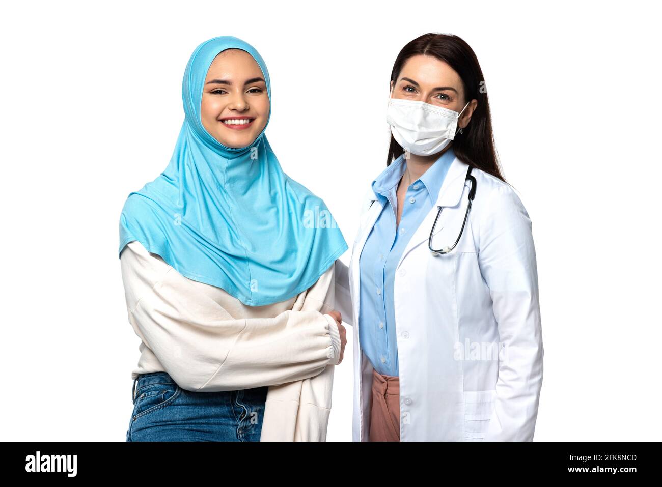 Médecin en manteau blanc et patient musulman souriant à la caméra isolé sur blanc Banque D'Images