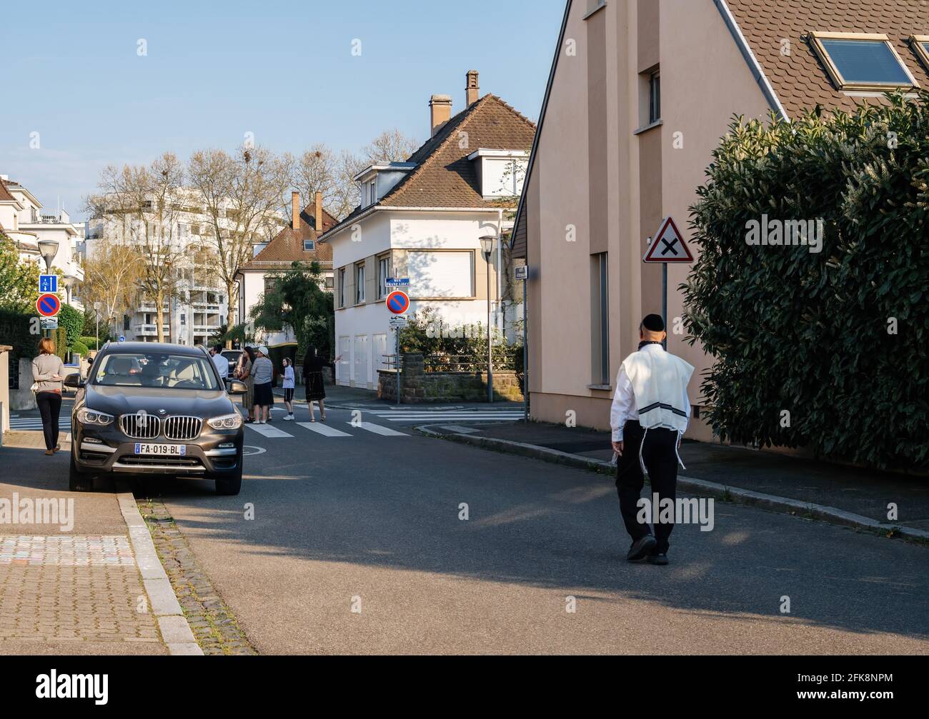 Vue arrière de l'homme juif Ultraortodoxos dans les vêtements de vacances de Pâques Marche sur la rue française Banque D'Images