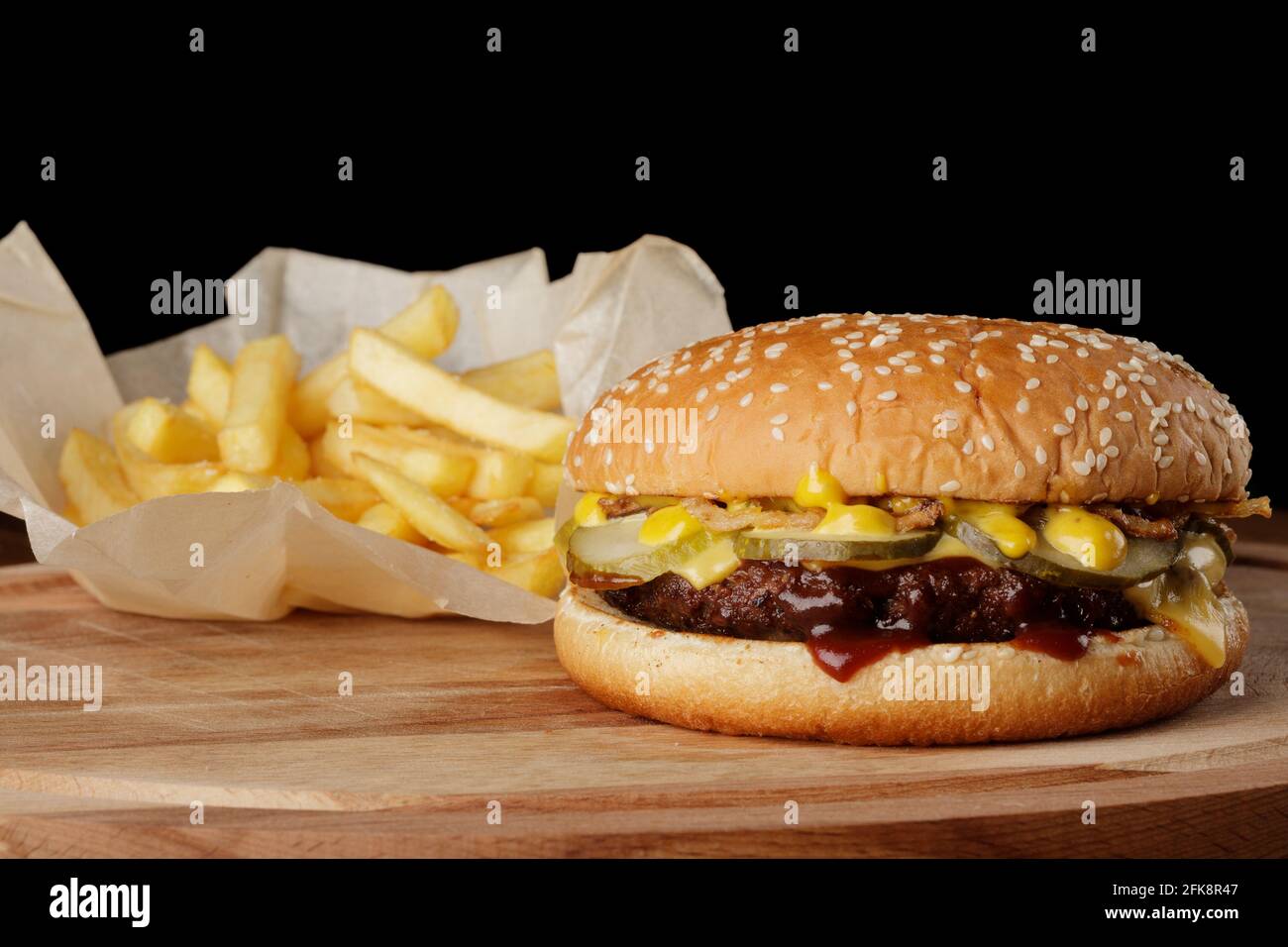 Hamburger avec frites et sauce. Arrière-plan en bois Banque D'Images