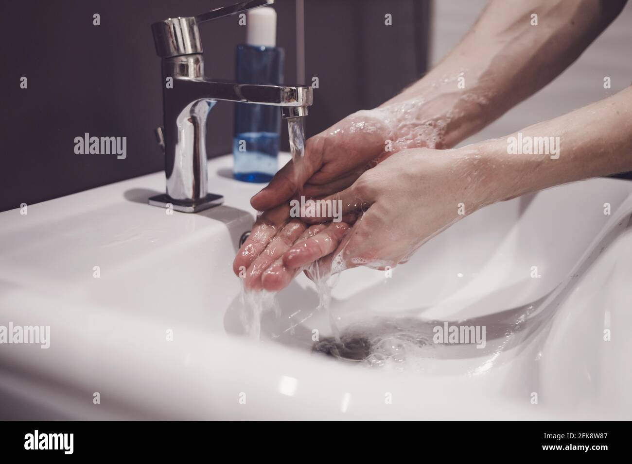 homme montrant l'hygiène des mains se laver les mains avec du savon dans de l'eau chaude pour la protection des germes du coronavirus. Arrêter le virus corona Banque D'Images