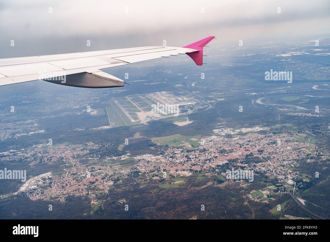 Vue depuis la fenêtre d'un avion volant sur la ville, les routes, la forêt verte, les champs Banque D'Images