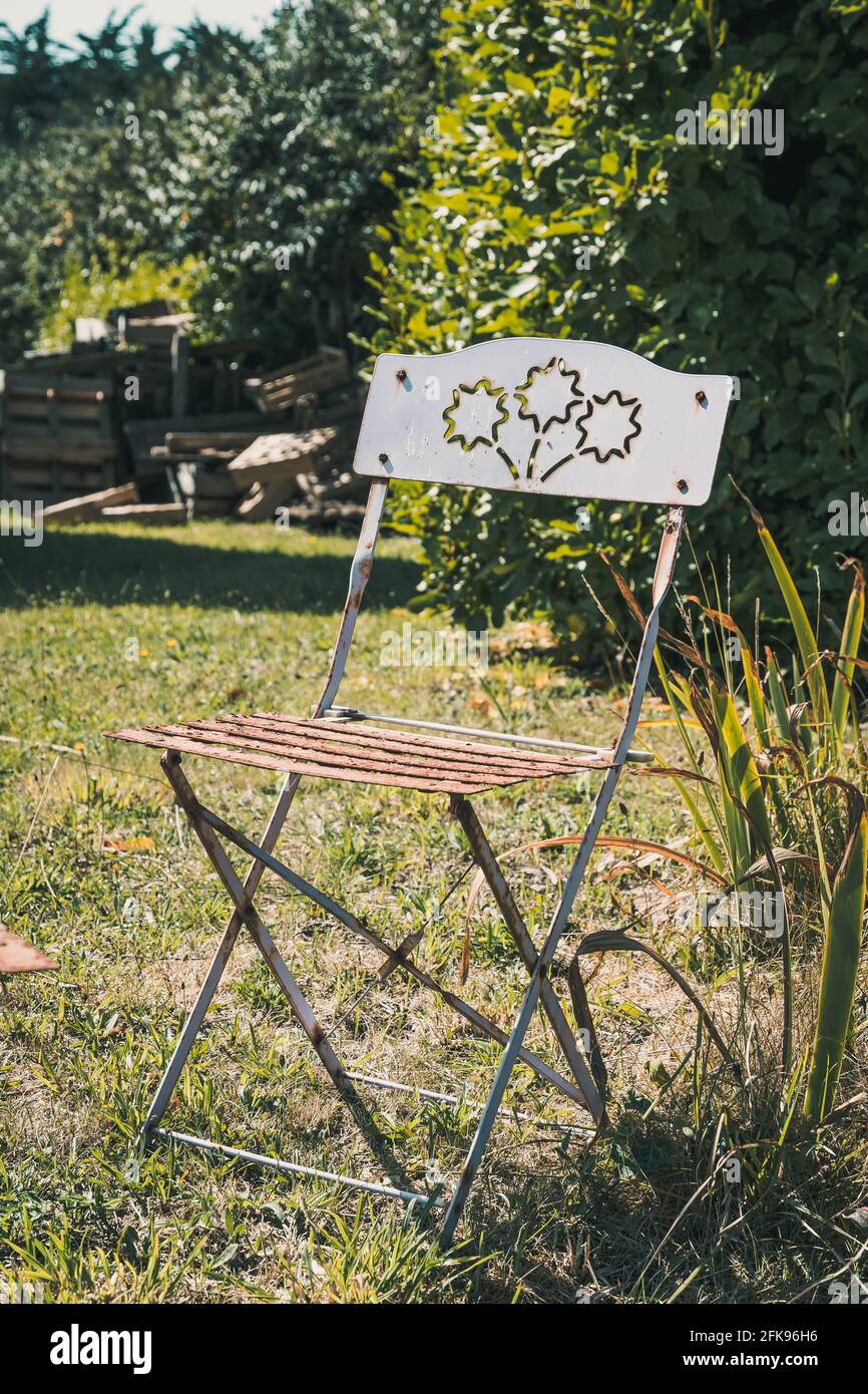 Chaise pliante en métal vintage avec décoration dans un jardin Photo Stock  - Alamy