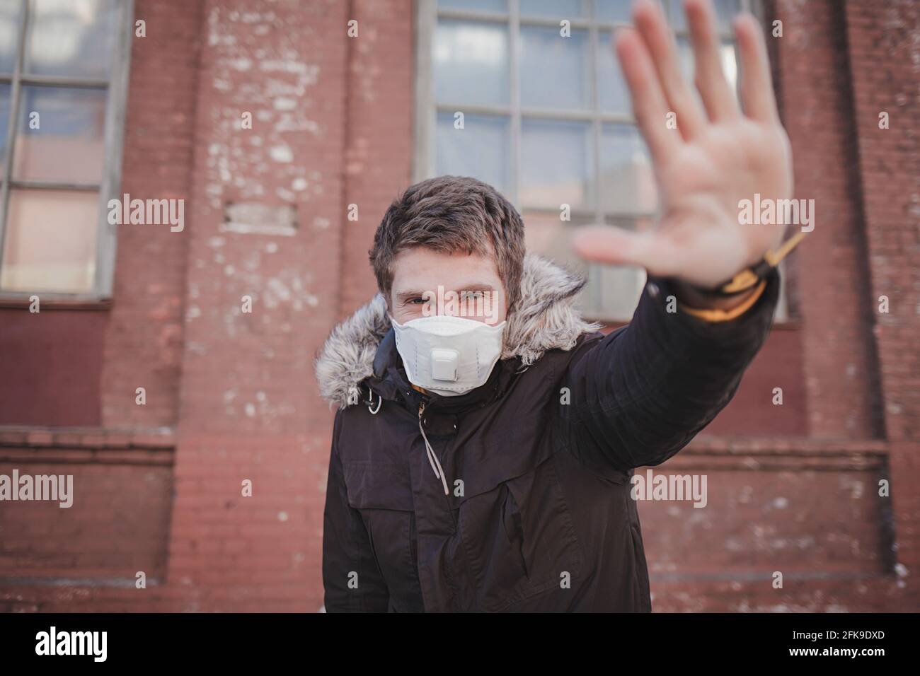 Homme européen portant un masque pour protéger les p2,5 et montrer les mains stop geste pour arrêter l'épidémie de virus corona. Coronavirus et pollution de l'air concept des p2,5 Banque D'Images