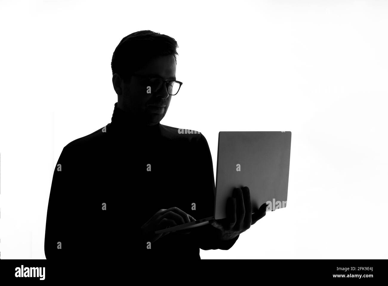 Homme tapant sur un ordinateur portable, isolé sur fond blanc. Banque D'Images