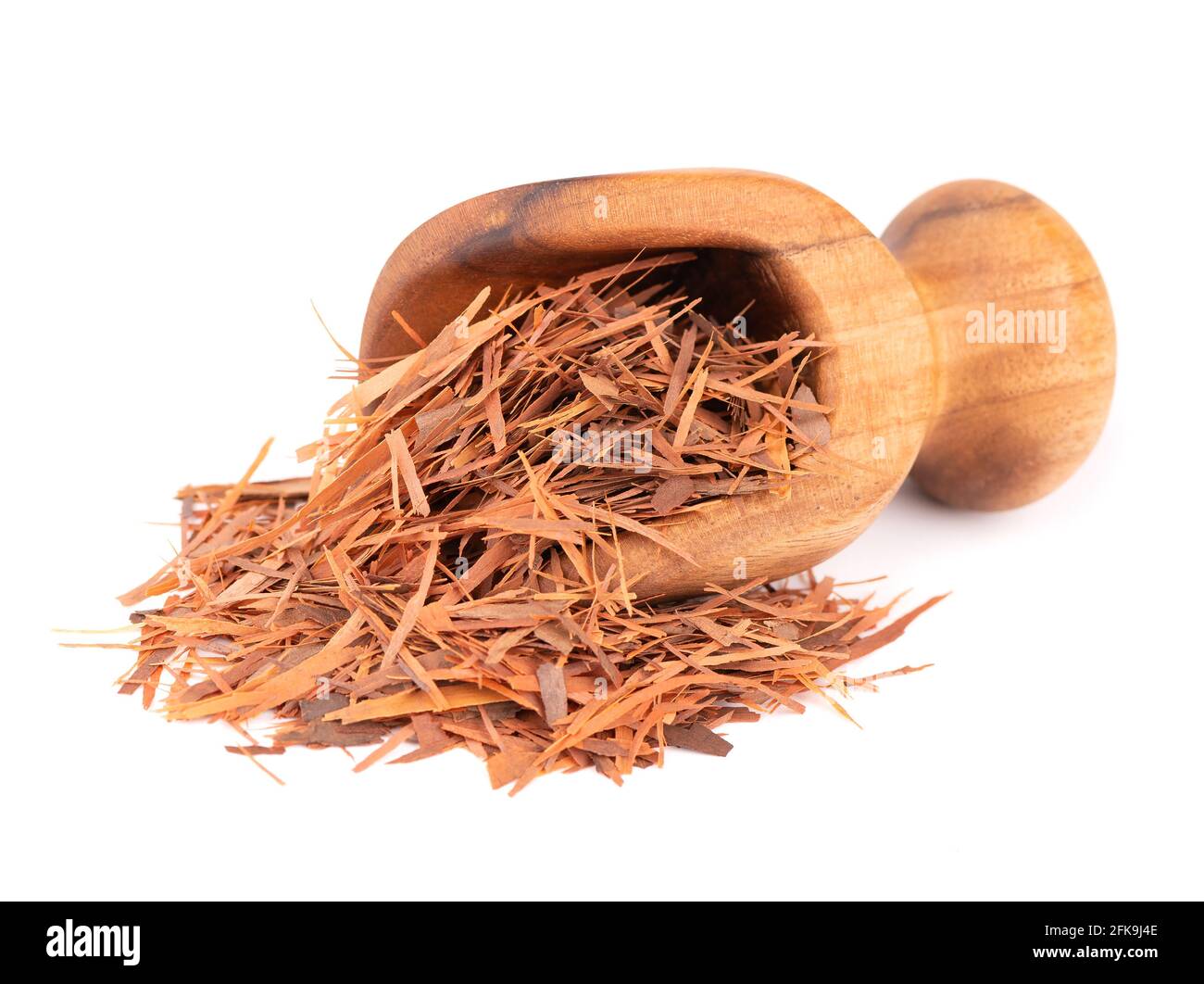 Tisane de Lapacho dans une cuillère en bois, isolée sur fond blanc. Thé sec Taheeboo naturel. Pau d'arco. Tabebuia heptophylla. Banque D'Images