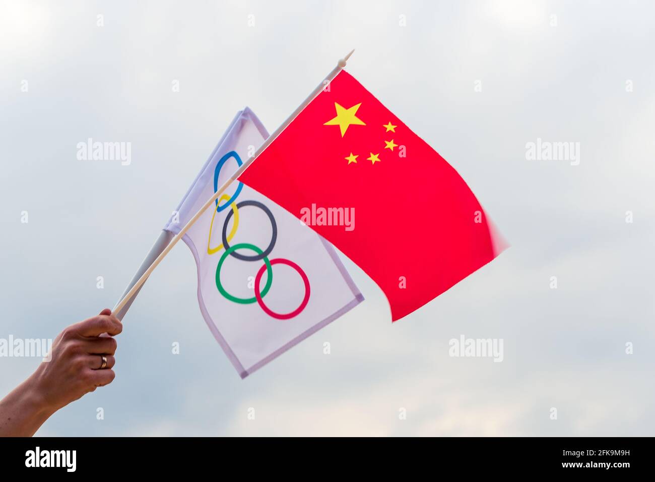 Fan signe le drapeau national de la Chine et le drapeau olympique avec le symbole jeux olympiques anneaux. Banque D'Images