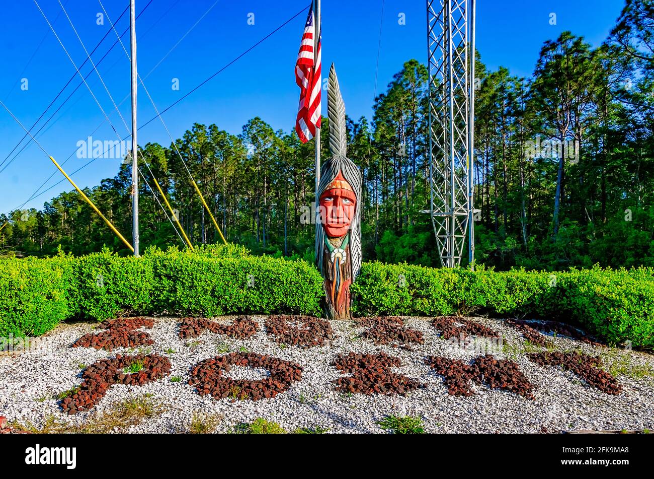 Un Indien en bois se dresse avec un drapeau américain à l'entrée de l'Indian point RV Resort, le 25 avril 2021, à Gautier, Mississippi. Banque D'Images