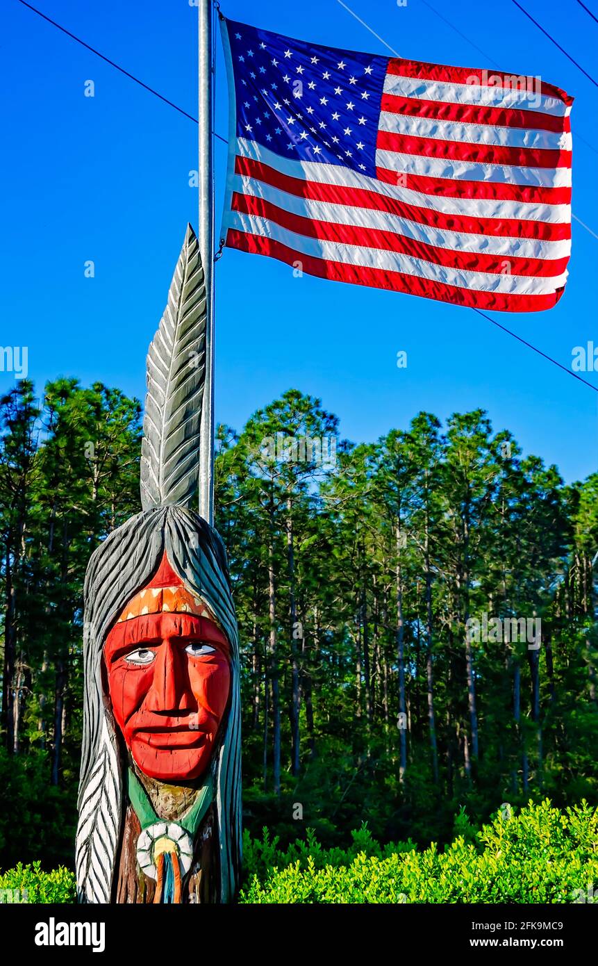 Un Indien en bois se dresse avec un drapeau américain à l'entrée de l'Indian point RV Resort, le 25 avril 2021, à Gautier, Mississippi. Banque D'Images