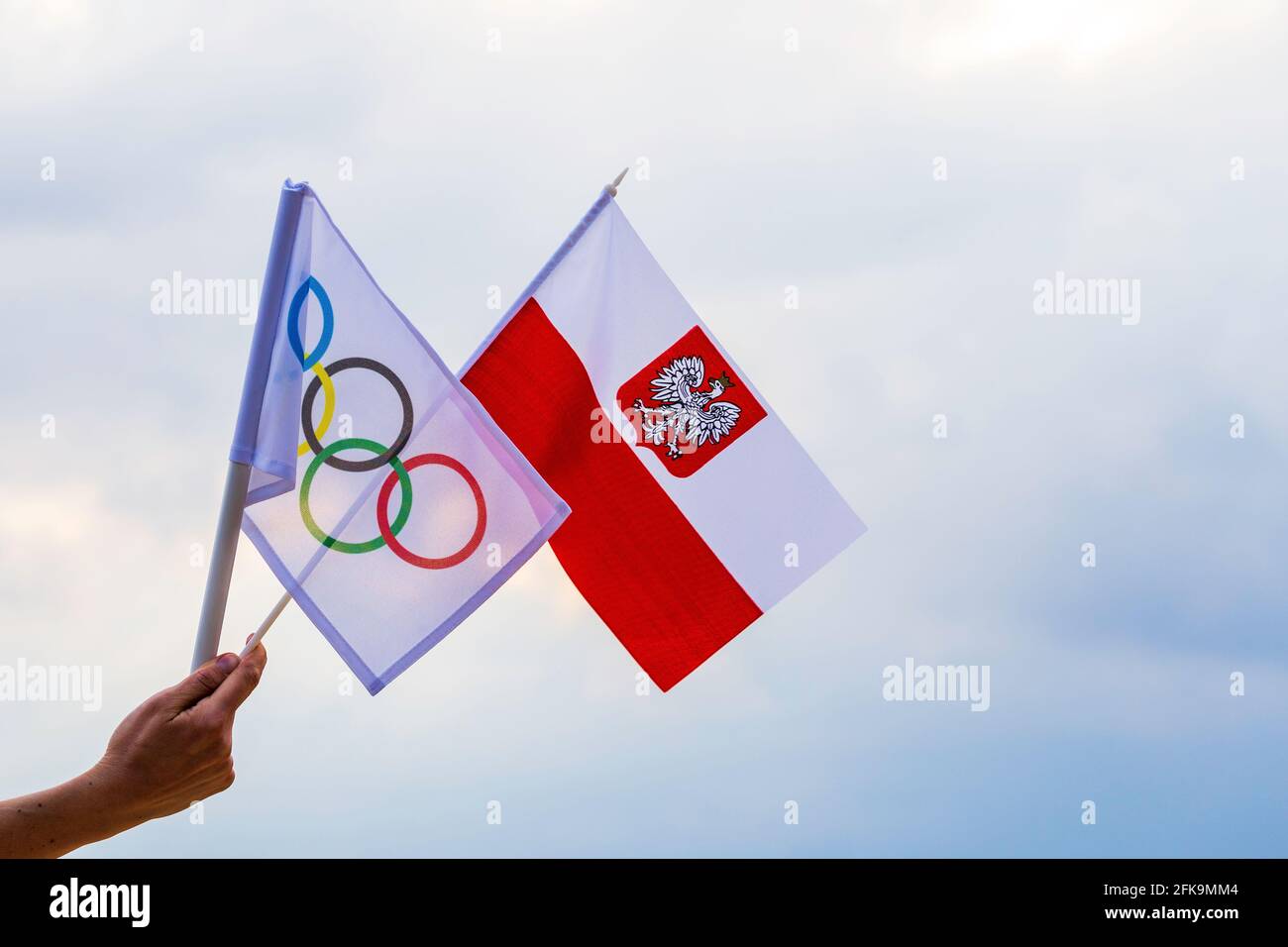Fan signe le drapeau national de la Pologne et le drapeau olympique avec le symbole anneaux olympiques. Banque D'Images