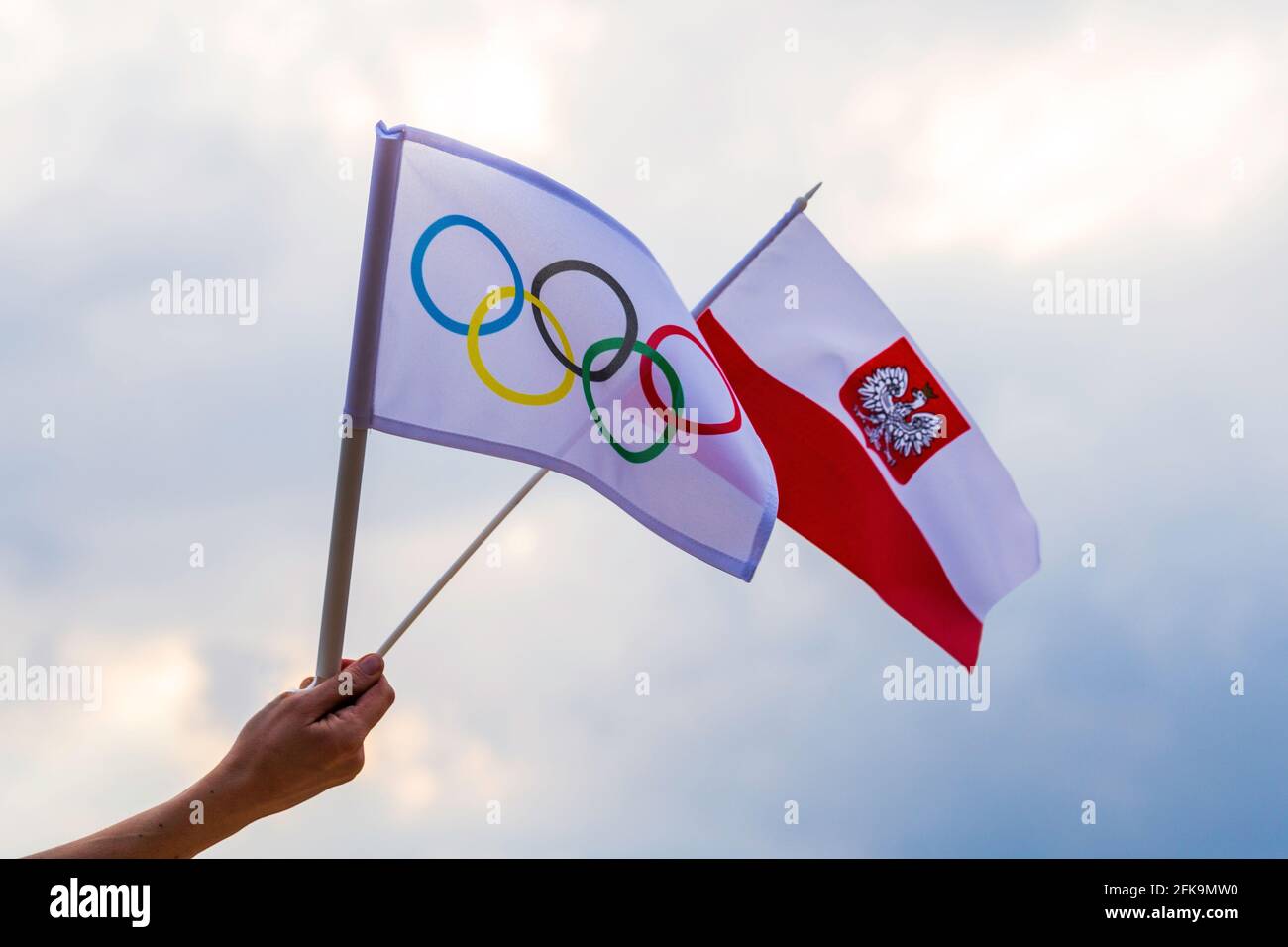 Fan signe le drapeau national de la Pologne et le drapeau olympique avec le symbole anneaux olympiques. Banque D'Images