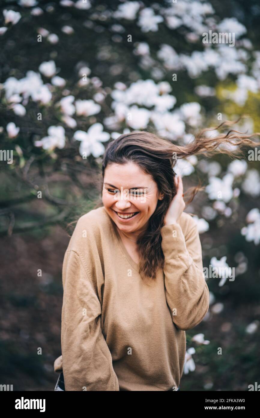 belle fille rit dans le parc avec magnolias Banque D'Images