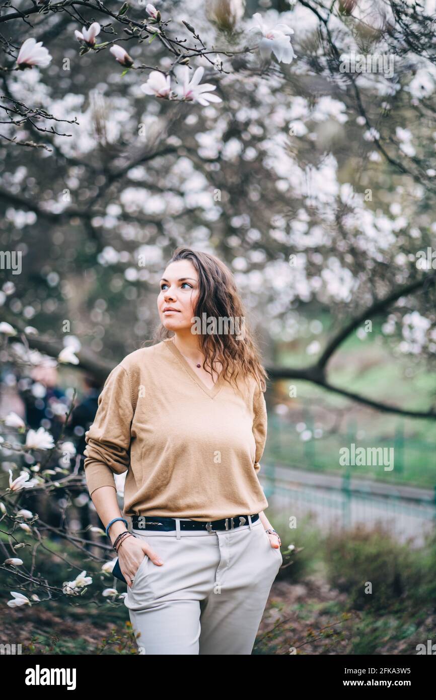 belle fille dans le parc avec magnolias Banque D'Images