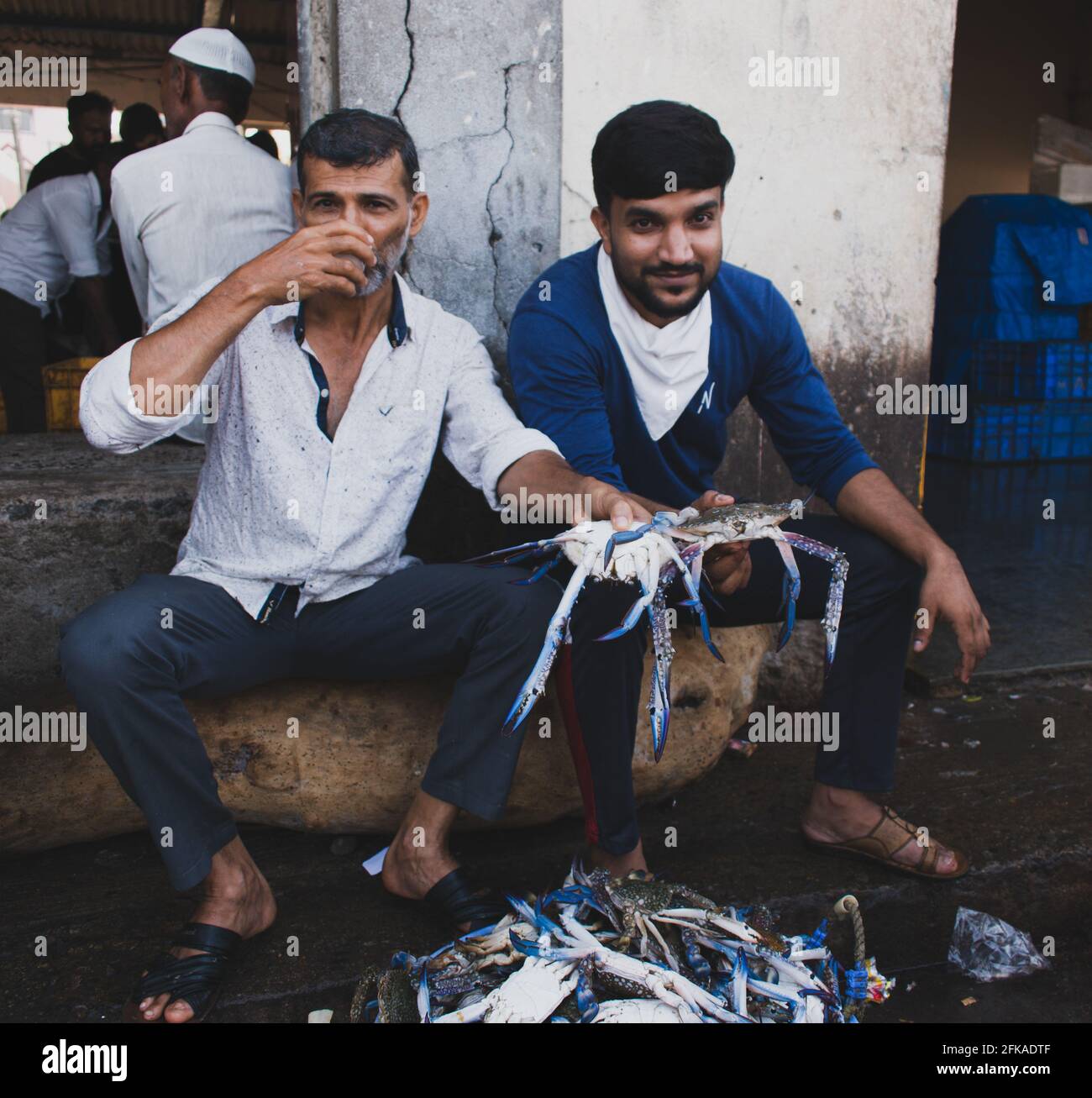 'Mangalore, Karnataka,Inde-1er avril 2021:pêcheurs indiens tenant le bleu de Chesapeake gaint dans leur main pour la vente. Banque D'Images