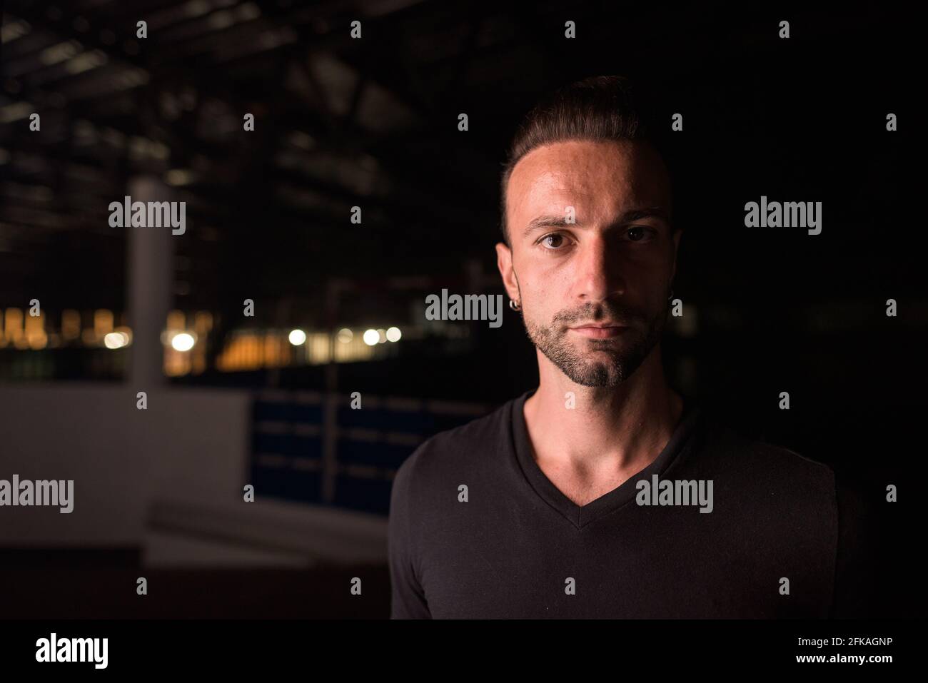 Portrait de l'homme beau la nuit dans le bâtiment du parking Banque D'Images