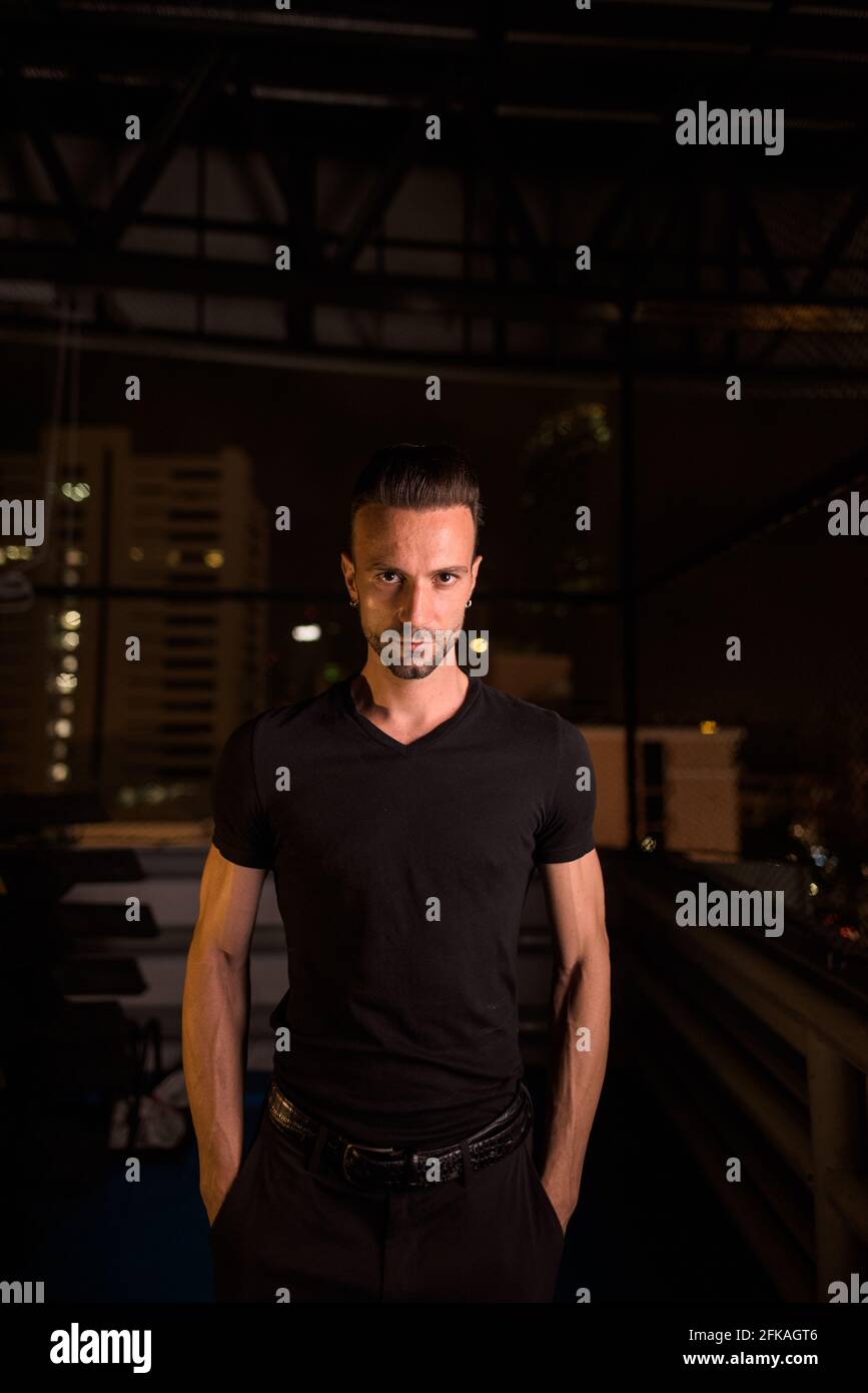 Portrait de l'homme beau la nuit dans le bâtiment du parking Banque D'Images